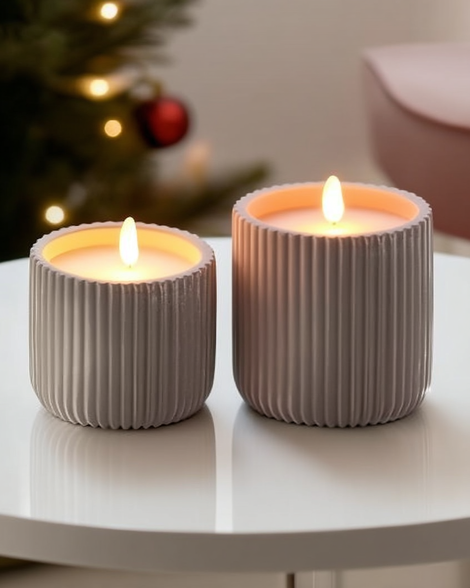 Two ribbed concrete flameless candles with a warm glow, one on a woven rattan coaster