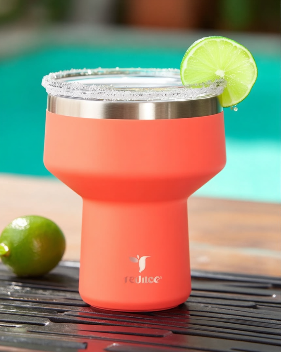 Coral insulated stainless steel tumbler with a sugar-rimmed lid and a lime wedge, set poolside on a wood table